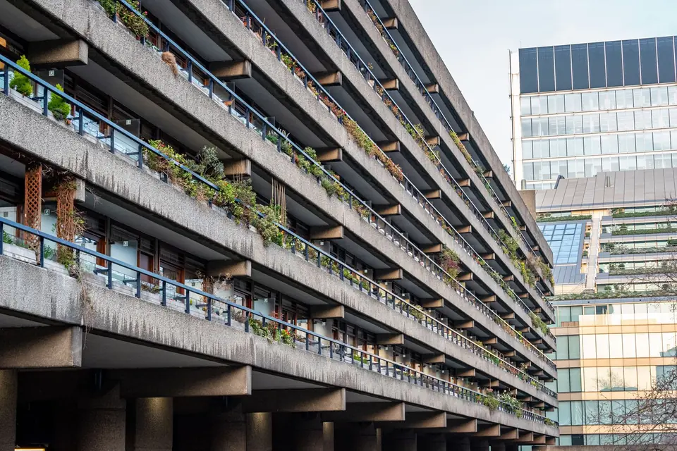 Concrete balconies lined with plants on a brutalist block of flats at the Barbican in London