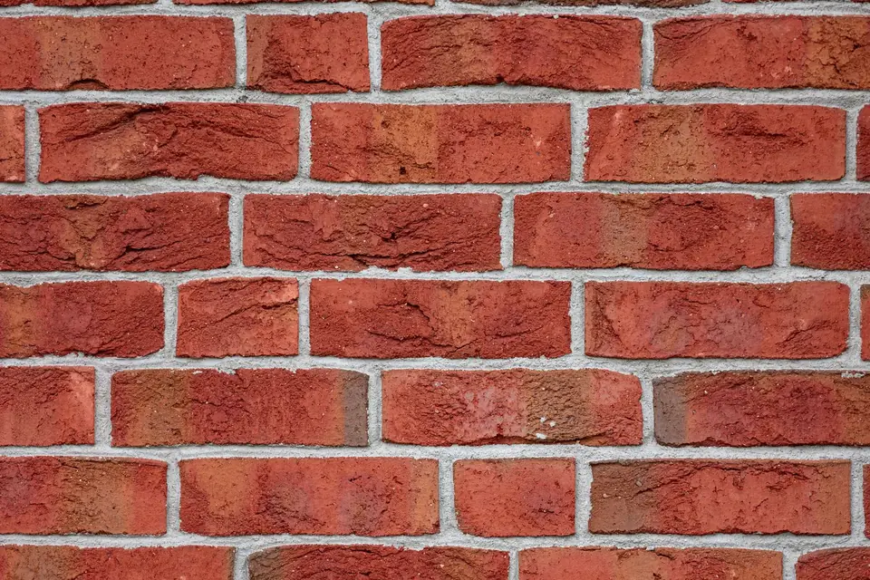 Close-up of a red brick wall laid in stretcher bond with pale mortar joints