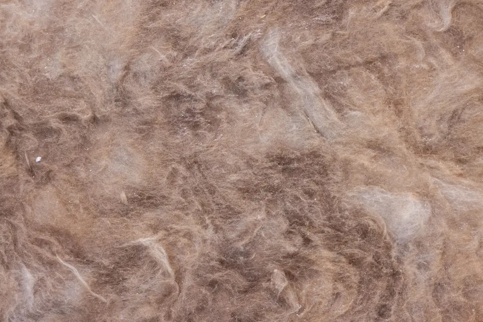 Close-up of thick brown mineral wool insulation, its matted glass fibres filling the frame
