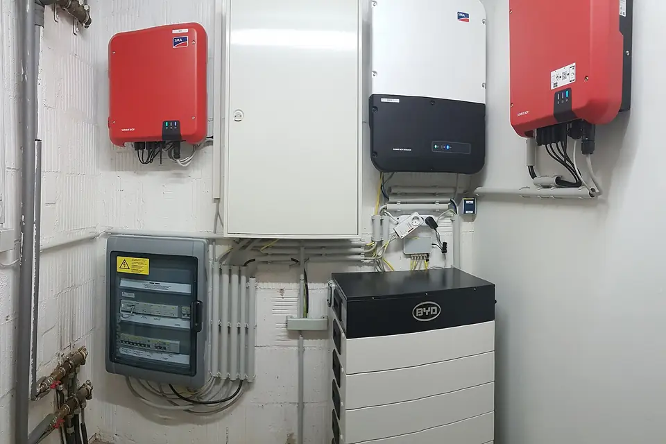 Wall-mounted solar inverters, a storage inverter and a stacked home battery unit in a household utility room